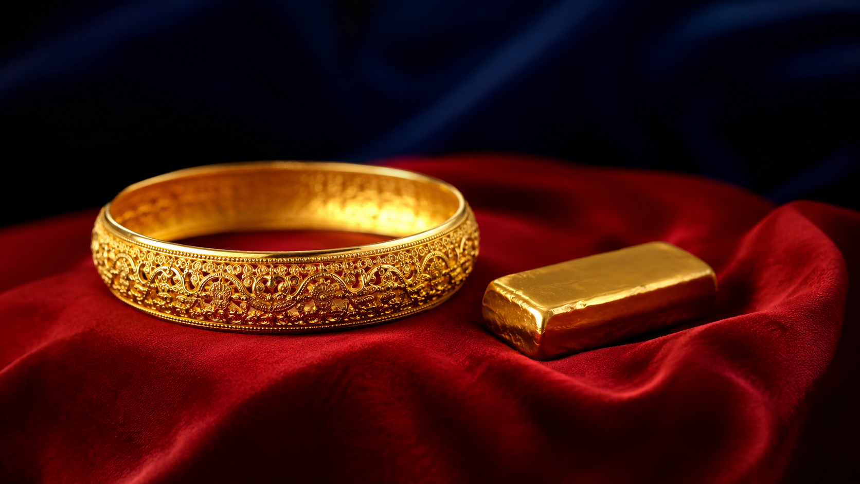 A deep yellow gold bangle beside a small gold bar on a red silk cloth